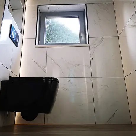 Fully tiled marble bathroom with black toilet
