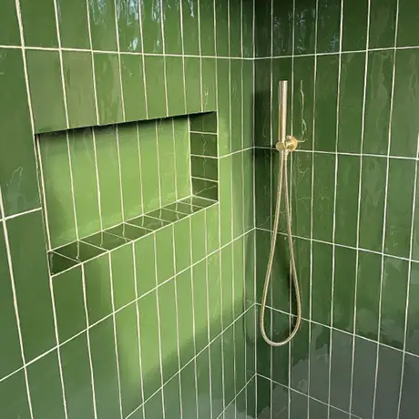 Olive green vertical tiled shower with nook