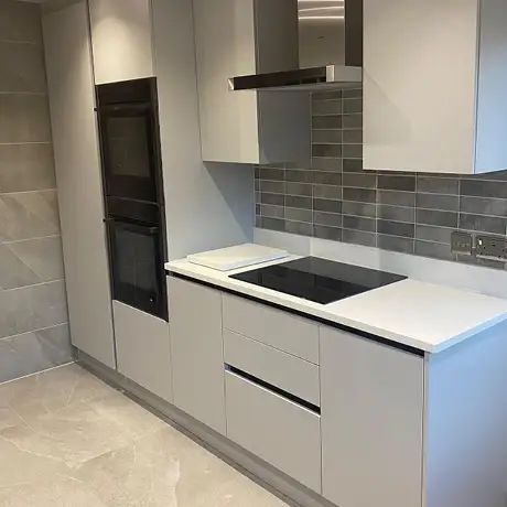 Modern white and grey kitchen with grey brick tiles in various shades