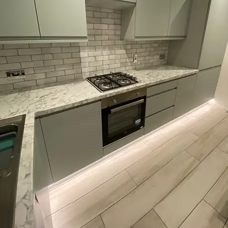 Grey and white tiled kitchen with tiled wood floor
