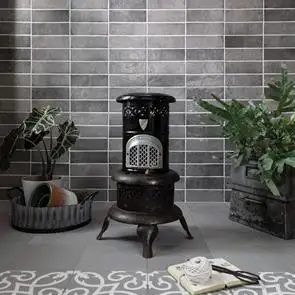 Dyroy grey tile on a feature wall in a traditional styled living space, with contrasti floor tiles and a log burner