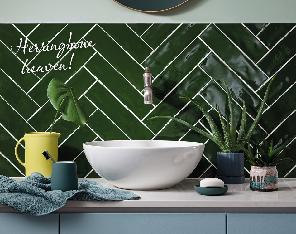 Poitiers Green wall tiles in a herringbone layout in a bathroom. 