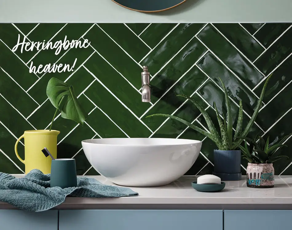 Poitiers Green wall tiles in a herringbone layout in a bathroom. 