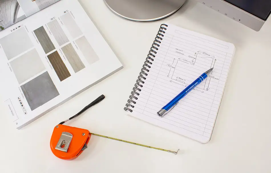 Tile measurements and tape measure on desk.