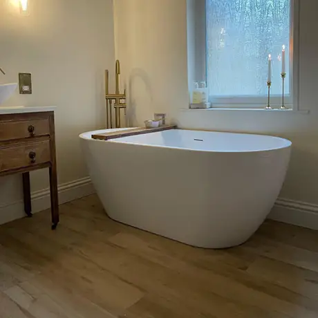 White roll top bath with wood effect bathroom floow tiles