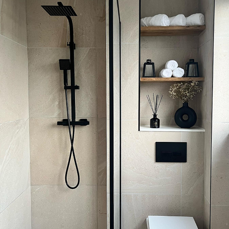 Stone effect tiled shower area and storage nook
