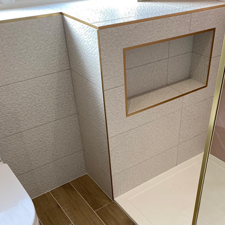 Textured white tiles in bathroom storage niche