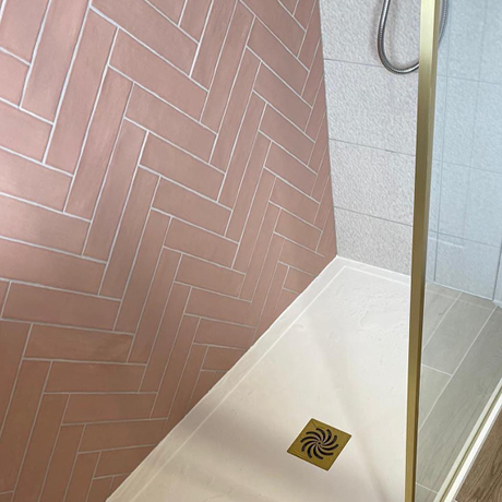 Pink herringbone tile layout on feature shower wall