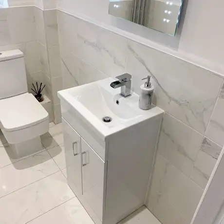 All white marble toilet and sink splashback
