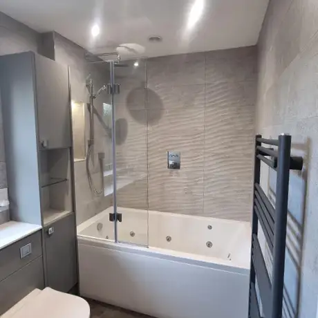 Wavy grey tiles in shower over bath