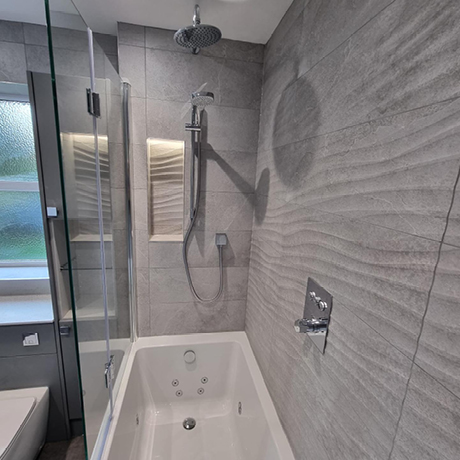 Grey tiles with wave design in shower over bath