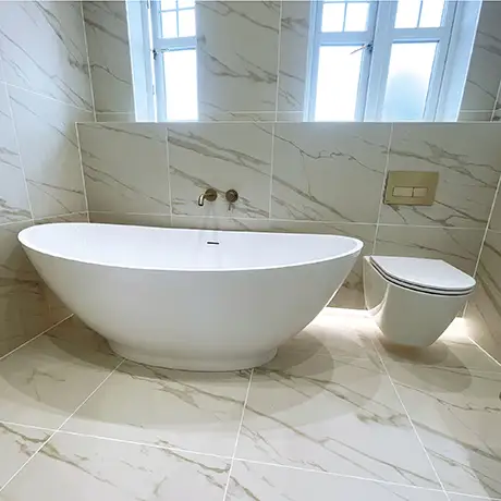 Freestanding bath and toilet in a marble-inspired bathroom featuring Marmori Calacatta White Matt