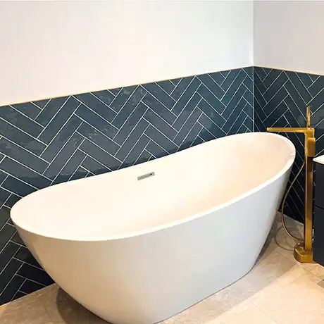 Freestanding bath featuring Poitiers Indigo on the wall in a herringbone layout