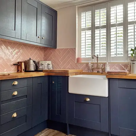 Pink kitchen spashback with navy units