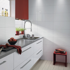 gloss white kitchen with matching gloss white tiles obeing used as a feature wall with wave tile splash back.