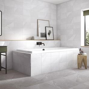 Melford light grey marble tile in a fully tiled bathroom setting with rectangular tiled in bath and black taps