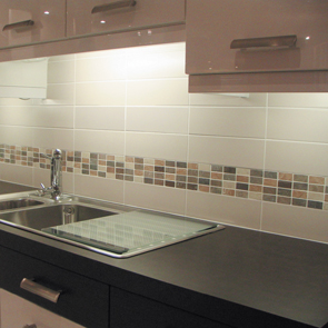 Cream wall tile worked together with brown shaded mosaic tiles on wall of kitchen.  
