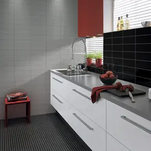 Gloss white kitchen with modern black mosaic floor And contrasting step glossy grey on the plain wall.