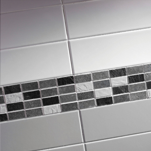 Close up shot of grey mosaic partnered with white and grey wall tiles.