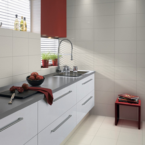 Galley style kitchen area with gloss white cabinets and complimenting streamline gloss white tile.