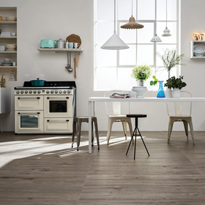 Traditional styled open plan kitchen with the treverkever ash tile on the floor with cream range cooker and shaker style cabinets