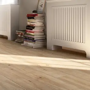 treverkever sand tile in a hallway with radiator cover and stack of books.