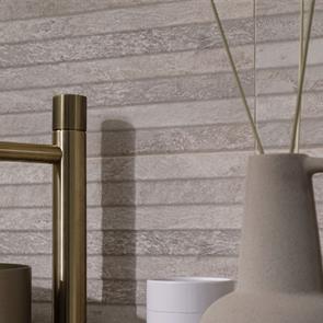 Table of champagne and flutes set against a modern feature wall tiled with Gemini Nature bone décors