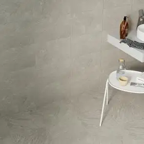 Matching wall and floor tiles in a bathroom setting with white furnishings