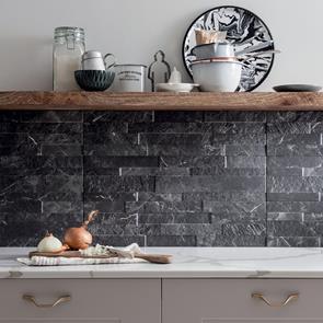 Kitchen splashback fully tiled in tiffany dark tile with floating shelves and latte coloured units.