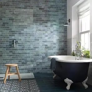 200x65 Dyroy aqua tile being used as a feature wall in open plan bathroom with claw foot black bath and oak stool