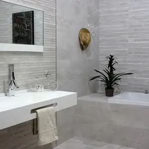 fully tiled bathroom with the nature grey plain tile and décor tile with tiled in bath panel