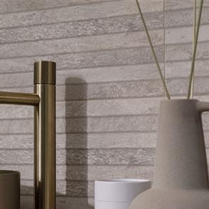 Table of champagne and flutes set against a modern feature wall tiled with Gemini Nature bone décors