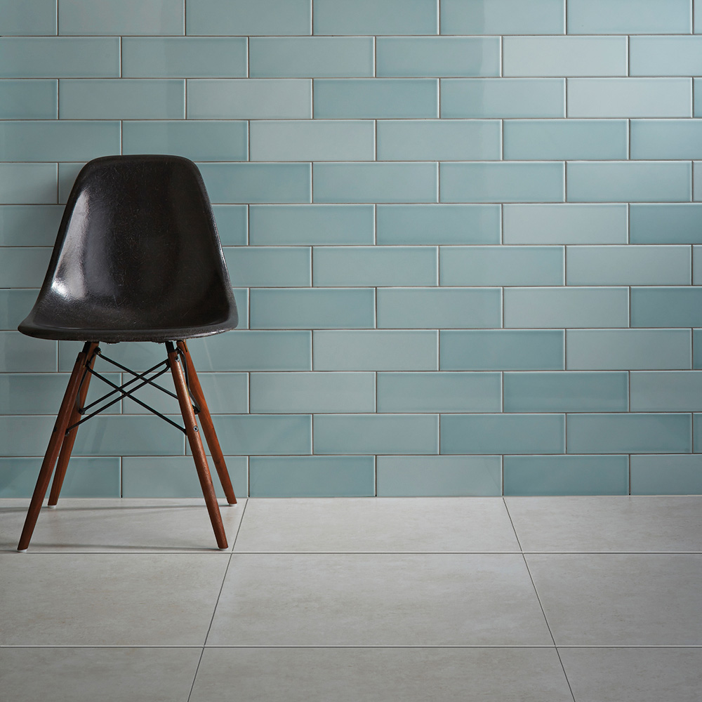 Savoy leaf tiles on a wall of a contemporary walk way with light grey floor tiles and contrasting black furniture