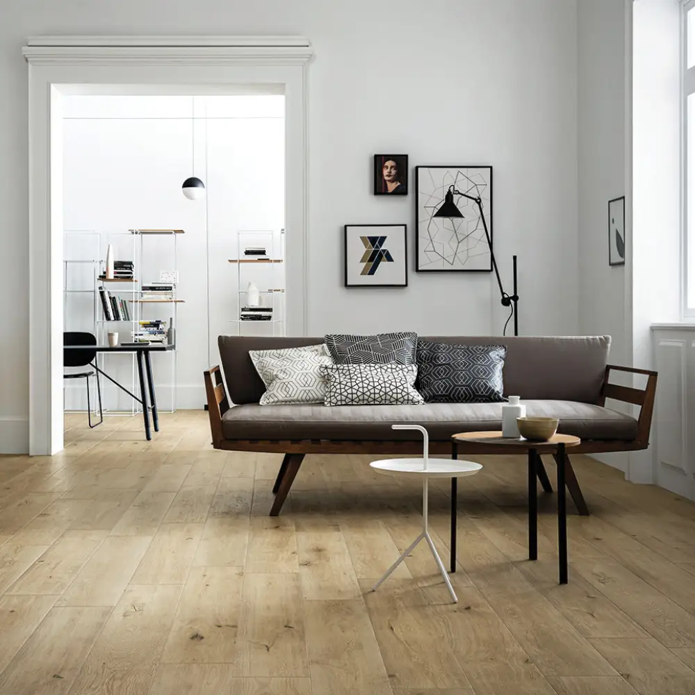 Natural wood effect treverkever tile in a large living space with white walls and black furniture