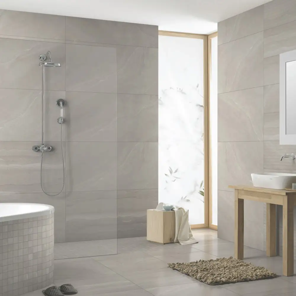 Bathroom with square light grey wall and floor tiles together with textured light grey rectangular tiles