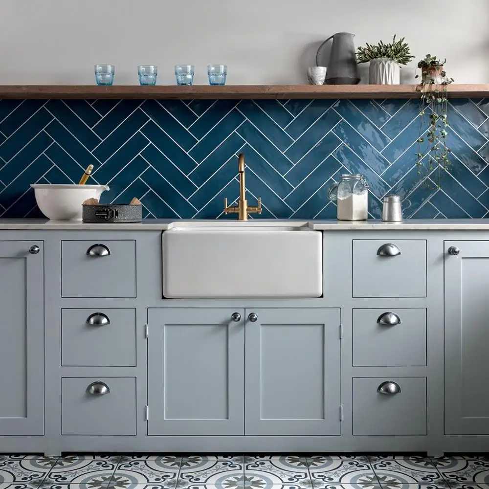 Poitiers azure tiles placed via herringbone on a kitchen wall with pale grey traditional kitchen units