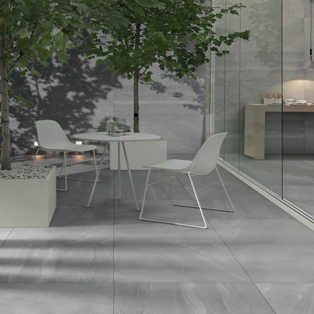 British Stone Grey outdoor porcelain tile on external patio with table, chairs and tree