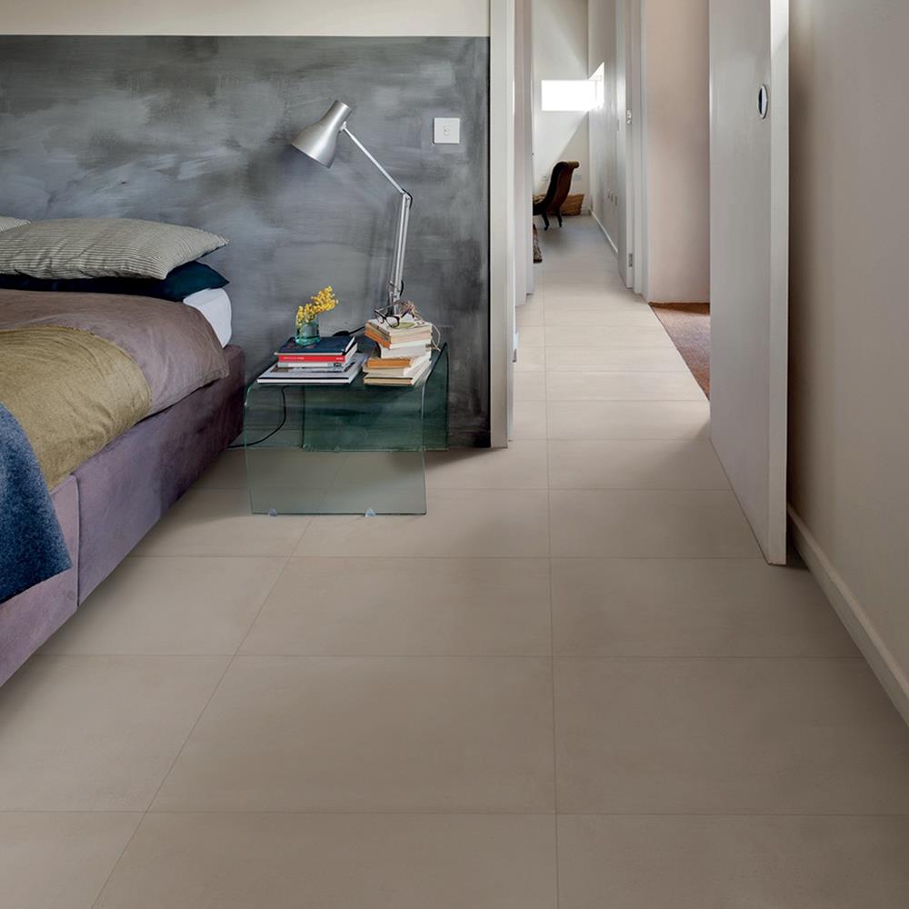 Loft beige porcelain tile in a large bedroom space with puruple bed sheets and contrasting grey wall