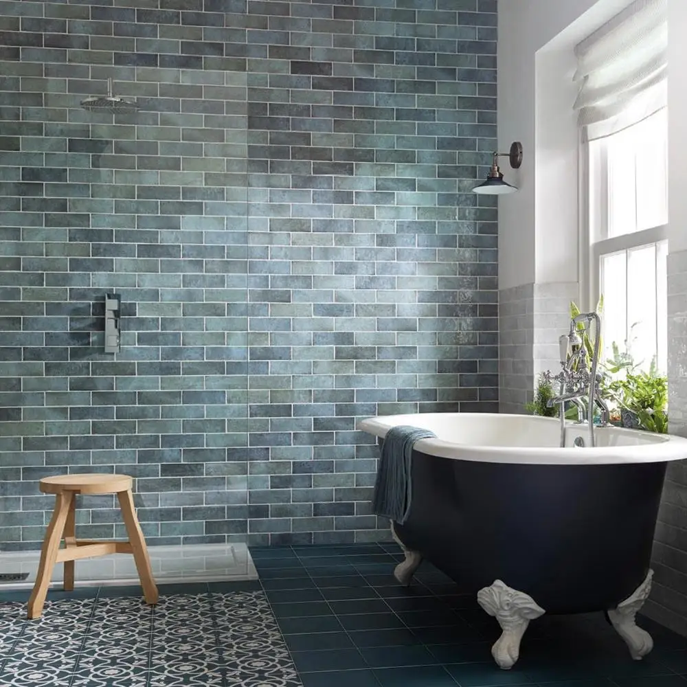 200x65 Dyroy aqua tile being used as a feature wall in open plan bathroom with claw foot black bath and oak stool