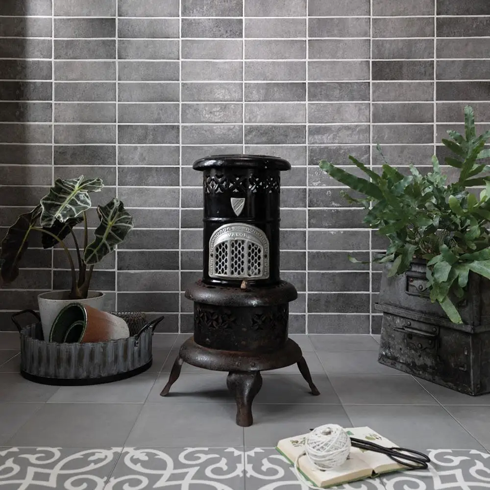 Dyroy grey tile on a feature wall in a traditional styled living space, with contrasti floor tiles and a log burner