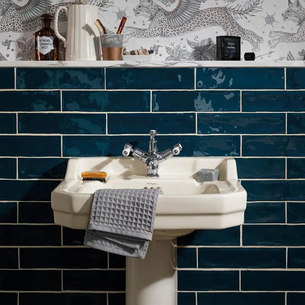Poitiers indigo tiles in a bathroom setting with a traditional styled sink and contemporary leopard wall paper